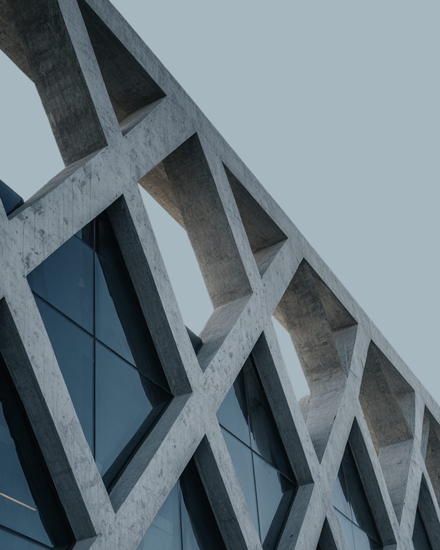 Concrete lattice façade against a pale sky